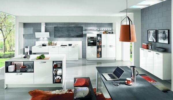 Moderne, helle Einbauküche mit Kochinsel, Esstisch und großen Fenstern im offenen Wohnraum.