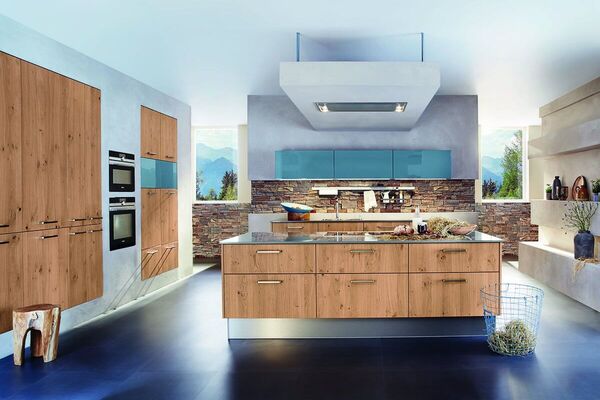 Moderne Einbauküche mit Holzfronten, Kochinsel, Steinwand und blauen Oberschränken.