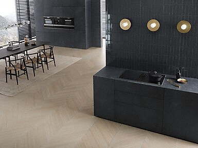 Moderne offene Küche mit dunklen Fronten, Esstisch und stilvoller Wandbeleuchtung.