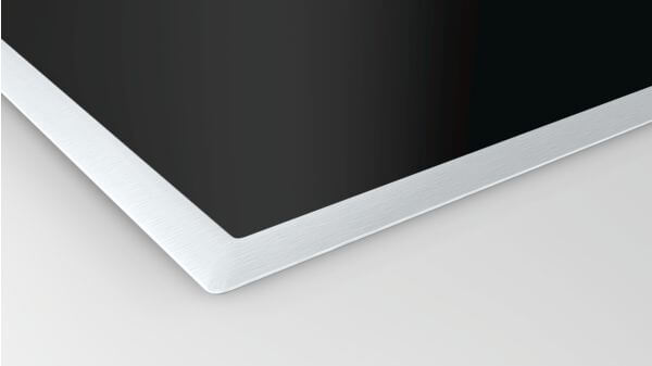 Ecke einer modernen schwarzen Glasplatte mit silbernem Metallrahmen auf hellem Untergrund.